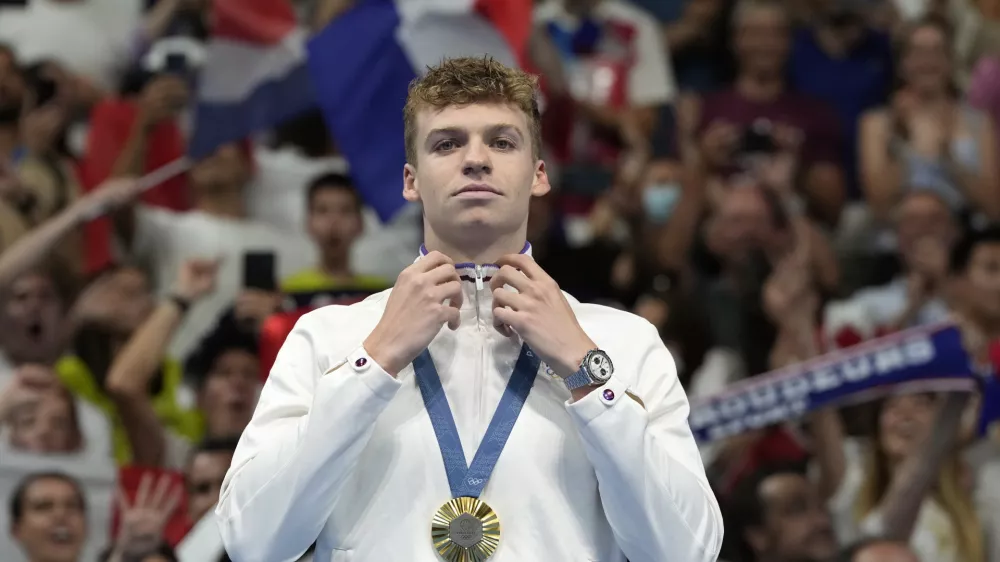 FILE - Leon Marchand of France, reacts after receiving his gold medal for the men's 200-meter individual medley final at the 2024 Summer Olympics, Friday, Aug. 2, 2024, in Nanterre, France. (AP Photo/Natacha Pisarenko, FIle)