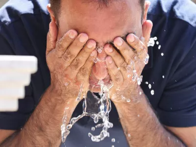 A tourist uses a fountain to cool off amid a heatwave, in Sarajevo, Bosnia and Herzegovina, August 13, 2024. REUTERS/Amel Emric