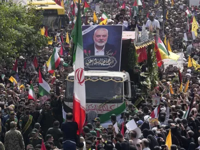 FILE - Iranians follow a truck, center, carrying the coffins of Hamas leader Ismail Haniyeh and his bodyguard during their funeral ceremony at Enqelab-e-Eslami (Islamic Revolution) Sq. in Tehran, Iran, Thursday, Aug. 1, 2024. (AP Photo/Vahid Salemi, File)