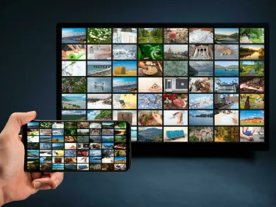 2E9EAW6 man holding mobile phone with many icons of video service on demand on background Oline TV VOD provider. Interface of video distribution service. Subs