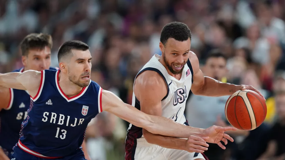 08 August 2024, France, Paris: USA's Stephen Curry and Serbia's Ognjen Dobric in action during the men's semi-final basketball match between Serbia and USA during the Paris 2024 Olympic Games at the Bercy Arena. Photo: Marcus Brandt/dpa