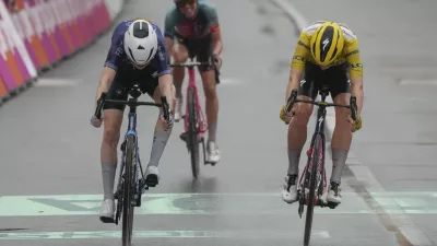 Netherlands Puck Pieterse, left, crosses the finish line ahead of Demi Vollering of The Netherlands, wearing the overall leader's yellow jersey, and Katarzyna Niewiadoma of Poland, rear, to win the fourth stage of the Tour de France Women cycling race with start in Valkenburg, Netherlands, and finish in Liege, Belgium, Wednesday, Aug. 14, 2024. (AP Photo/Peter Dejong)