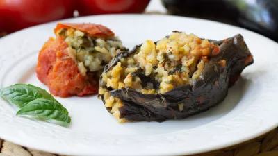 Traditional azerbaijani eggplant dolma also called three sisters made vegan: an aubergine and a tomato stuffed with spicy rice and basil instead of the minced beef in a white plate / Foto: Mehriban Aliyeva