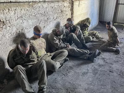 In this photo provided by the Ukrainian Security Service Press Office, over 100 Russian prisoners of war captured by a Security Service special unit during one military action are seen in a shelter in Kursk region, Russia, Wednesday, Aug. 14, 2024. (Ukrainian Security Service Press Office via AP)