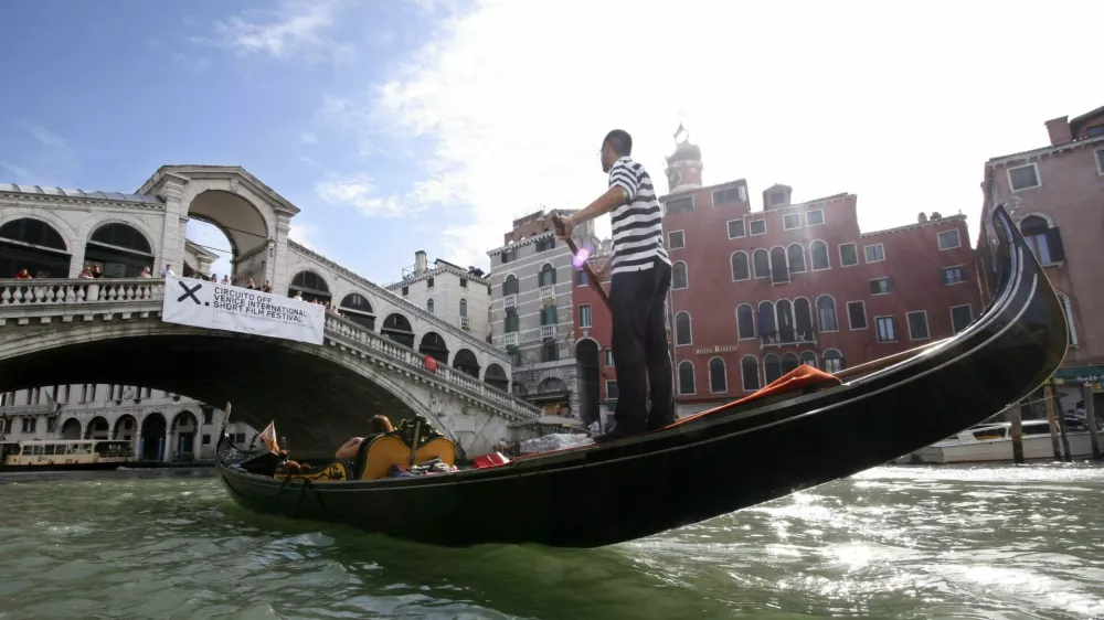 A gondolier rows his gondola next to Rialto Bridge in Venice August 29, 2006. The 63nd Venice Film Festival opens on August 30, bringing 11 days of showbiz parties and glamour to the lagoon city.  REUTERS/Fabrizio Bensch (ITALY)