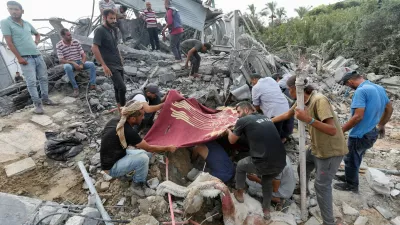 Palestinians stand at the site of an Israeli airstrike on a shelter housing displaced people, amid the conflict between Israel and Hamas, in central Gaza Strip, August 17, 2024. Reuters/Ramadan Abed