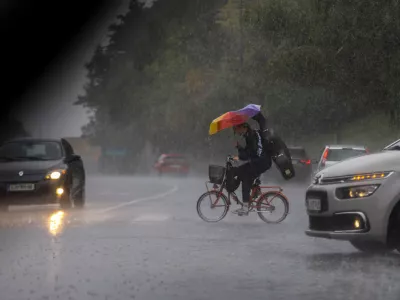 kolesar- 15.09.2022 - Močno deževje in poplave v Ljubljani - neurje - meteorna voda je zalila več garaž, podhodov, kletnih in stanovanjskih prostorov, skladišč in poslovnih prostorov, pa tudi prostore osnovne šole in vrtca, lekarne ter Narodno galerijo.Foto: Luka Cjuha