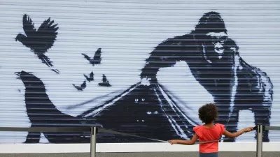 A child views a reproduction of a recent Banksy artwork at London Zoo, after the zoo removed the original piece whilst deciding where to relocate it, in London, Britain, August 19, 2024. REUTERS/Toby Melville   TPX IMAGES OF THE DAY