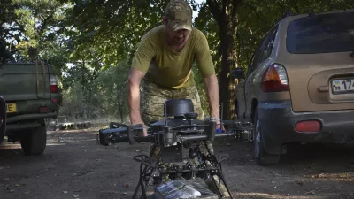 A soldier of Ukraine's 141st separate infantry brigade loads a drone with a parcel for soldiers on a mission at the frontline in Zaporizhzhia region, Ukraine, Monday, Aug. 19, 2024. (AP Photo/Andriy Andriyenko)