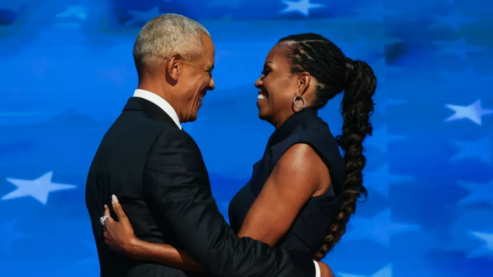 Former U.S. first lady Michelle Obama embraces her husband, former U.S. President Barack Obama, on stage before his speech during Day 2 of the Democratic National Convention (DNC) in Chicago, Illinois, U.S., August 20, 2024. REUTERS/Alyssa Pointer