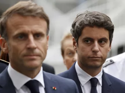 FILE - Then French Education and Youth Minister Gabriel Attal watches French President Emmanuel Macron talking to the press at the Gambetta high school in Arras, northeastern France, Friday Oct. 13, 2023. Gabriel Attal was named Tuesday Jan.9, 2024 as France's youngest-ever prime minister, as President Emmanuel Macron seeks a fresh start for the rest of his term amid growing political pressure from the far right. (Ludovic Marin, Pool via AP, File)