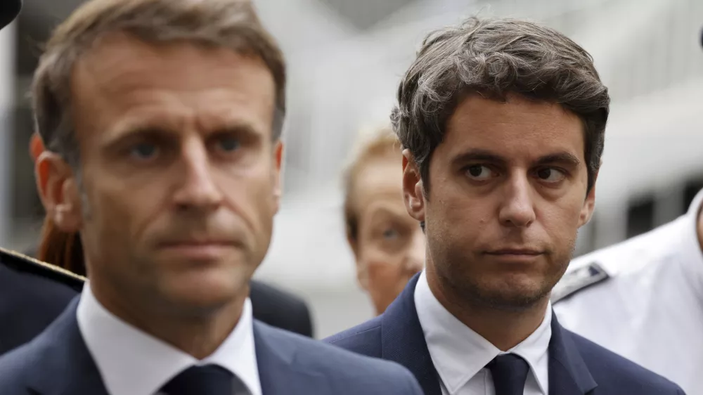 FILE - Then French Education and Youth Minister Gabriel Attal watches French President Emmanuel Macron talking to the press at the Gambetta high school in Arras, northeastern France, Friday Oct. 13, 2023. Gabriel Attal was named Tuesday Jan.9, 2024 as France's youngest-ever prime minister, as President Emmanuel Macron seeks a fresh start for the rest of his term amid growing political pressure from the far right. (Ludovic Marin, Pool via AP, File)