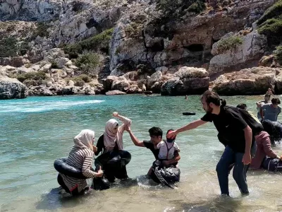 Migrants come ashore near Faros, island of Ikaria, Greece, August 19, 2024 in this still image obtained from video. Vasilis Ferraras/via REUTERS THIS IMAGE HAS BEEN SUPPLIED BY A THIRD PARTY. MANDATORY CREDIT. NO RESALES. NO ARCHIVES. TIME AND DATE STAMP FROM SOURCE