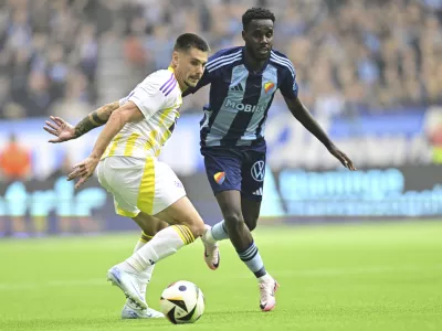 Maribor's Gregor Sikosek, left, and Djurgården's Tokmac Nguen challenge for the ball during the Conference League playoff first leg soccer match between Djurgardens IF and NK Maribor at Stockholm Arena, in Stockholm, Sweden, Thursday, Aug. 22, 2024. (Magnus Lejhall/TT News Agency via AP)