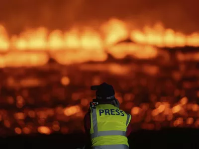 Photographers and journalists on location filming and reporting on the new fissure north of Grindavik, Iceland, Thursday, Aug. 22, 2024, (AP Photo/Marco di Marco)