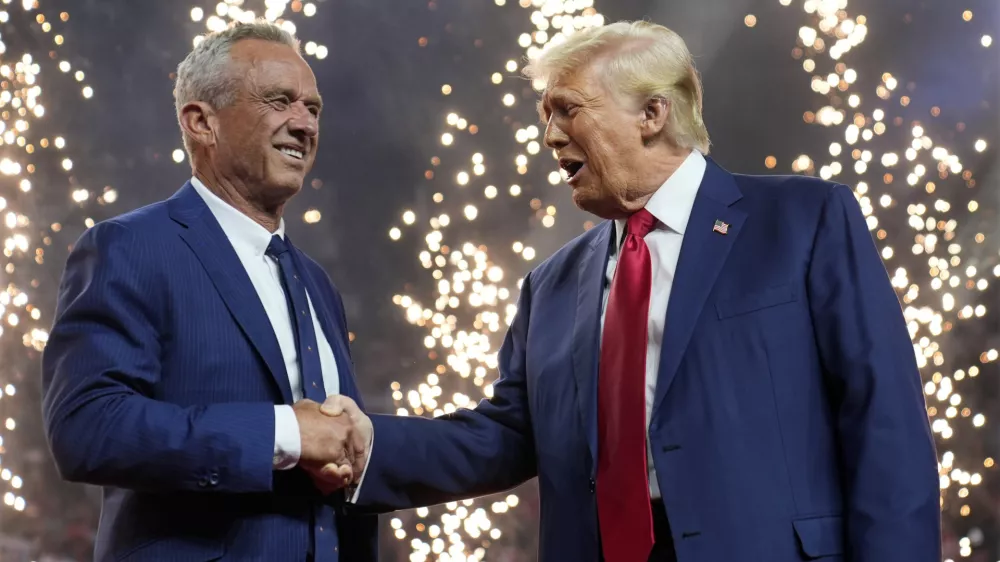 Republican presidential nominee former President Donald Trump shakes hands with Independent presidential candidate Robert F. Kennedy Jr. at a campaign rally at the Desert Diamond Arena, Friday, Aug. 23, 2024, in Glendale, Ariz. (AP Photo/Evan Vucci)