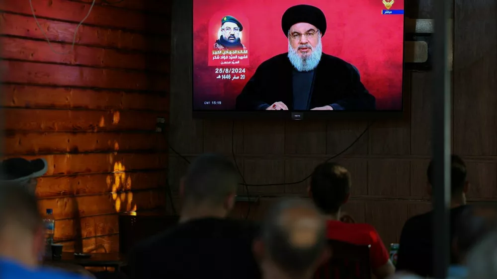 People watch Lebanon's Hezbollah leader Sayyed Hassan Nasrallah delivering a televised address, as they sit at a cafe in Beirut, Lebanon August 25, 2024. REUTERS/Mohamed Azakir