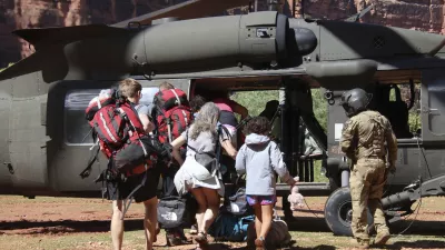 U.S. Army soldiers of the Arizona National Guard guide tourists trapped by flash flooding into a UH-60 Blackhawk, Saturday, Aug. 24, 2024, on the Havasupai Reservation in Supai, Ariz. (Maj. Erin Hannigan/U.S. Army via AP)