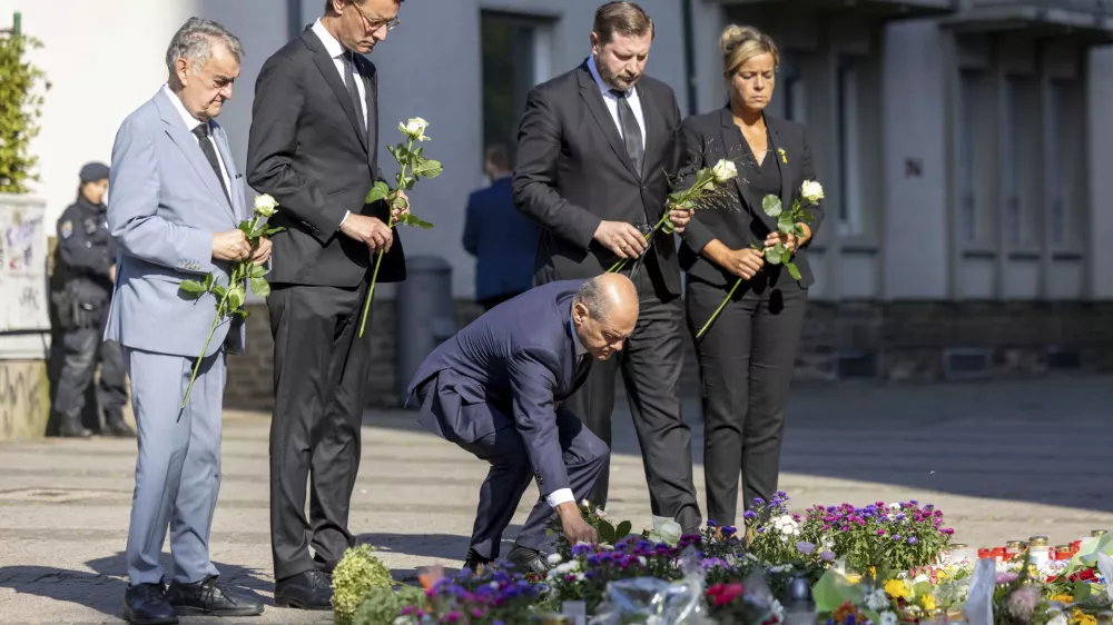 From left, Herbert Reul, Minister of the Interior of North Rhine-Westphalia, Hendrik Wüst, Minister President of North Rhine-Westphalia, German Chancellor Olaf Scholz, Tim Kurzbach, Mayor of Solingen, and Mona Neubaur, Deputy Minister President of North Rhine-Westphalia lay flowers, near the scene of a knife attack, in Solingen, Germany, Monday, Aug. 26, 2024. (Thomas Banneyer/dpa via AP)