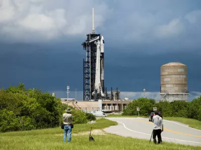 A SpaceX Falcon 9 rocket is prepared for launch of Polaris Dawn, a private human spaceflight mission, as photographers look on at the Kennedy Space Center in Cape Canaveral, Florida, U.S. August 26, 2024. Two crew members are expected to attempt the first-ever private spacewalk. REUTERS/Joe Skipper