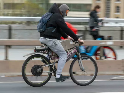 2M09T4E A man commuting on an e-bike across London Bridge, London, UK. 18 Nov 2022