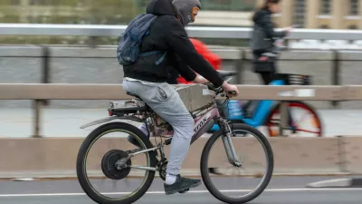 2M09T4E A man commuting on an e-bike across London Bridge, London, UK. 18 Nov 2022