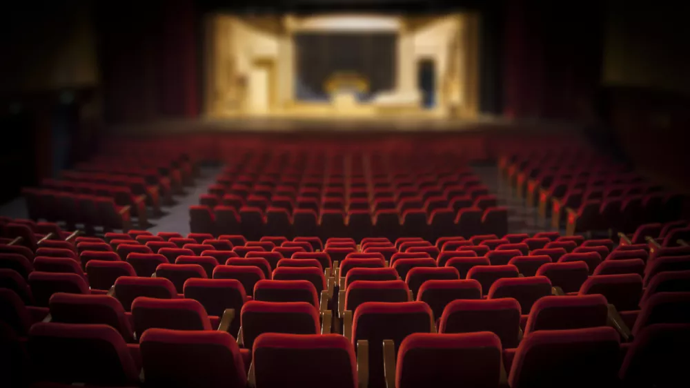 Empty red armchairs of a theater ready for a show