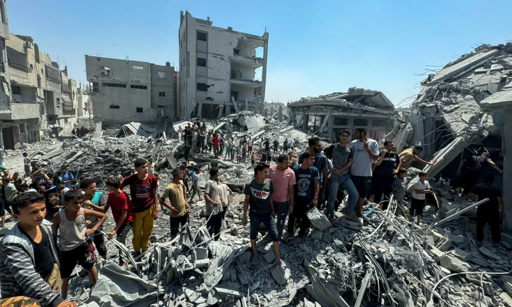 Palestinians gather at the site of an Israeli strike that destroyed several houses, amid Israel-Hamas conflict, in Khan Younis in the southern Gaza Strip August 27, 2024. REUTERS/Mohammed Salem