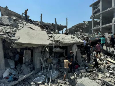 Palestinians gather at the site of an Israeli strike that destroyed several houses, amid Israel-Hamas conflict, in Khan Younis in the southern Gaza Strip August 27, 2024. REUTERS/Mohammed Salem