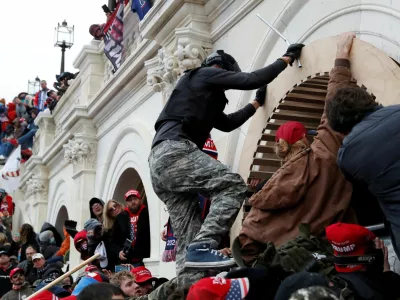 FILE PHOTO: Pro-Trump protesters scale a wall as they storm the U.S. Capitol Building, during clashes with Capitol police at a rally to contest the certification of the 2020 U.S. presidential election results by the U.S. Congress, in Washington, U.S, January 6, 2021. REUTERS/Shannon Stapleton/File Photo