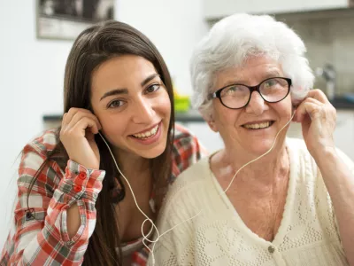 Granddaughter listening music with her grandmother at home. / Foto: Bojan89