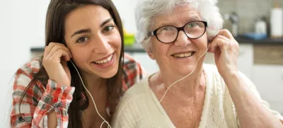 Granddaughter listening music with her grandmother at home. / Foto: Bojan89