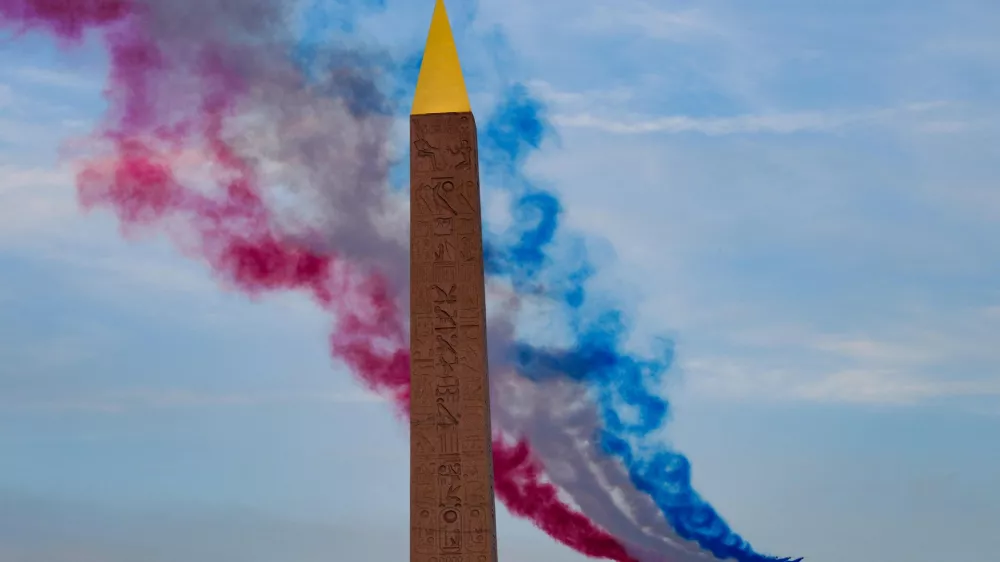 28 August 2024, France, Paris: The "Patrouille de France" aerobatic team of the French Air Force flies past the Egyptian Luxor Obelisk during the opening ceremony of the Paralympic Summer Games. Photo: Dimitar Dilkoff/AFP/dpa