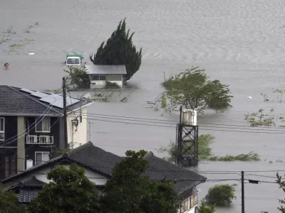 Farmland along a river is flooded by heavy rains caused by a typhoon in Yufu, Oita prefecture, western Japan, Thursday, Aug. 29, 2024. (Kyodo News via AP)