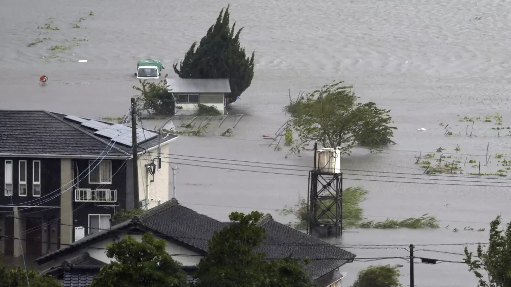 Farmland along a river is flooded by heavy rains caused by a typhoon in Yufu, Oita prefecture, western Japan, Thursday, Aug. 29, 2024. (Kyodo News via AP)