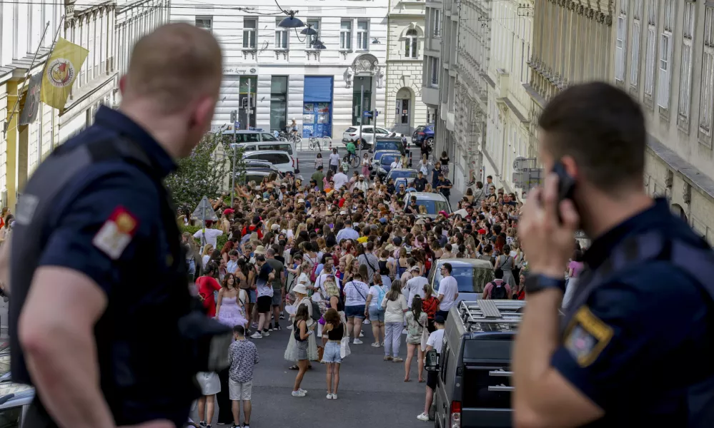 Austrian police officers watch swifts gathering in the city centre in Vienna on Thursday, Aug.8, 2024. Organizers of three Taylor Swift concerts in the stadium in Vienna this week called them off on Wednesday after officials announced arrests over an apparent plot to launch an attack on an event in the Vienna area such as the concerts. (AP Photo/Heinz-Peter Bader)