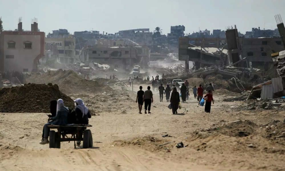 Palestinians walk near rubble, after Israeli forces withdrew from the area, following a ground operation, amid the ongoing conflict between Israel and Hamas, in Khan Younis, in the southern Gaza Strip, August 30, 2024. REUTERS/Hatem Khaled