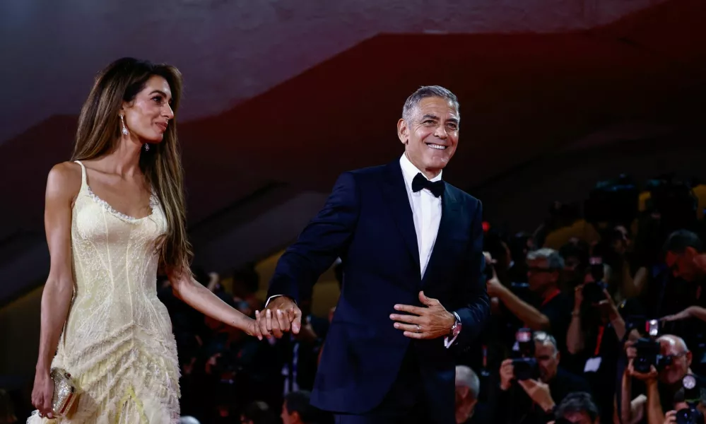 George Clooney and Amal Clooney walk on the red carpet during arrivals the movie "Wolfs" presented out of competition, during the 81st Venice Film Festival, in Venice, Italy, September 1, 2024. REUTERS/Yara Nardi