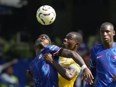 Chelsea's Noni Madueke, left, and Crystal Palace's Tyrick Mitchell, center, fight for the ball during the English Premier League soccer match between Chelsea and Crystal Palace, at the Stamford Bridge Stadium in London, Sunday, Sept. 1, 2024. (AP Photo/Frank Augstein)