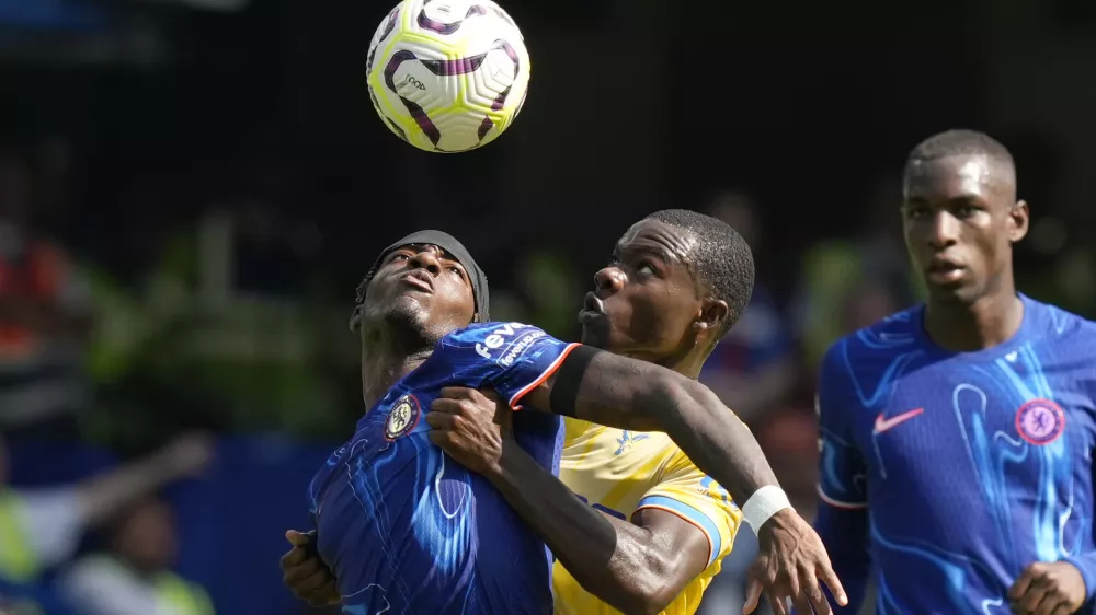 Chelsea's Noni Madueke, left, and Crystal Palace's Tyrick Mitchell, center, fight for the ball during the English Premier League soccer match between Chelsea and Crystal Palace, at the Stamford Bridge Stadium in London, Sunday, Sept. 1, 2024. (AP Photo/Frank Augstein)