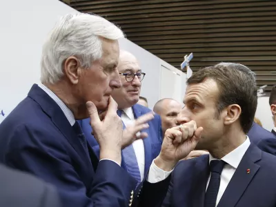 FILE - French President Emmanuel Macron, right, whispers to European Union chief Brexit negotiator Michel Barnier as he visits the International Agriculture Fair, in Paris, France. President Emmanuel Macron named the former EU Brexit negotiator as France's new prime minister on Thursday after more than 50 days of caretaker government. (AP Photo/Michel Euler, File)