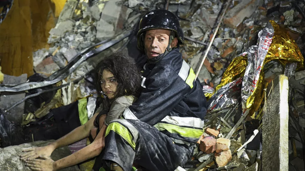 In this photo provided by the National Police of Ukraine on Sept. 3, 2024, a rescue worker pulls out from under the rubble an injured girl at a hotel damaged by a Russian strike in Zaporizhzhia, Ukraine. (National Police of Ukraine via AP)