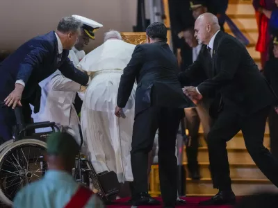 Papua New Guinea's deputy Prime Minister John Rosso, right, and rear-Admiral Philip Polewara, second from left, reach out to help Pope Francis keep his balance during a welcome ceremony at Port Moresby's "Jackson" International Airport, Friday, Sept. 6, 2024. As a second leg of his 11-day trip to Asia and Oceania Pope Francis's visit to Papua New Guinea will take him to a remote part of the South Pacific island nation where Christianity is a recent addition to traditional spiritual beliefs developed over millennia.(AP Photo/Gregorio Borgia)