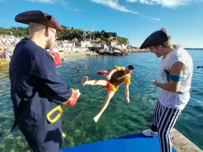 Dijaki višjih letnikov so svoje mlajše kolege drugega za drugim pometali v morje. Foto: Vesna Levičnik