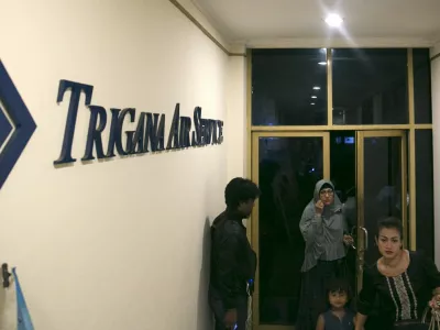 ﻿People walk into the entrance of Trigana Air's office in Jakarta, Indonesia August 16, 2015. Villagers in Indonesia's remote and mountainous eastern Papua region reported that an aircraft had crashed, a Trigana Air official said on Sunday, several hours after an aircraft carrying 54 people went missing, media reports said. REUTERS/Darren Whiteside