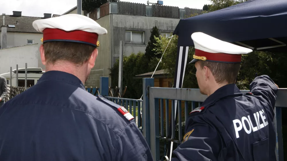 Two policemen are seen at the backyard entrance of a house that was the scene of a crime of incest and abuse in Amstetten, Lower Austria, Saturday, May 3, 2008 as the gathering of evidence continues. A man allegedly held his daughter captive in a dungeon of his house for 24 years, abusing her and fathering her seven children. Authorities investigating the Austrian man accused of imprisoning and raping his daughter are awaiting old court records that media say document a 1967 rape allegation. Lower Austria prosecutor Gerhard Sedlacek told The Associated Press Saturday that he did not yet know the contents of the file. He refused to confirm reports that Fritzl had a previous record for a sexual crime. (AP Photo/Kerstin Joensson)