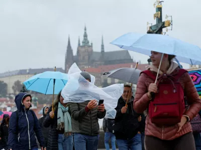 People walk across the medieval Charles Bridge during a rainstorm in Prague, Czech Republic, September 13, 2024. REUTERS/David W Cerny