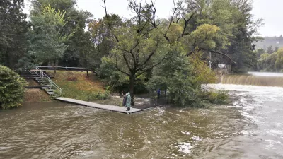 13 September 2024, Czech Republic, Brno: A photo taken from the pedestrian bridge between the Brno districts of Komin and Jundrov shows people taking a selfie with the raised level of the Svratka River at their own risk. The Morava River Basin Authority is releasing water from the Brno dam to reduce the impact of expected flooding due to heavy rainfall. Photo: Pavel Weber/CTK/dpa