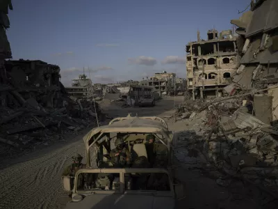 Israeli soldiers move next to buildings destroyed by the Israeli military in the Gaza Strip on Friday, Sept. 13, 2024. (AP Photo/Leo Correa)