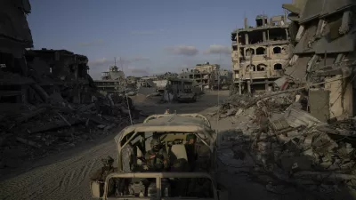 Israeli soldiers move next to buildings destroyed by the Israeli military in the Gaza Strip on Friday, Sept. 13, 2024. (AP Photo/Leo Correa)